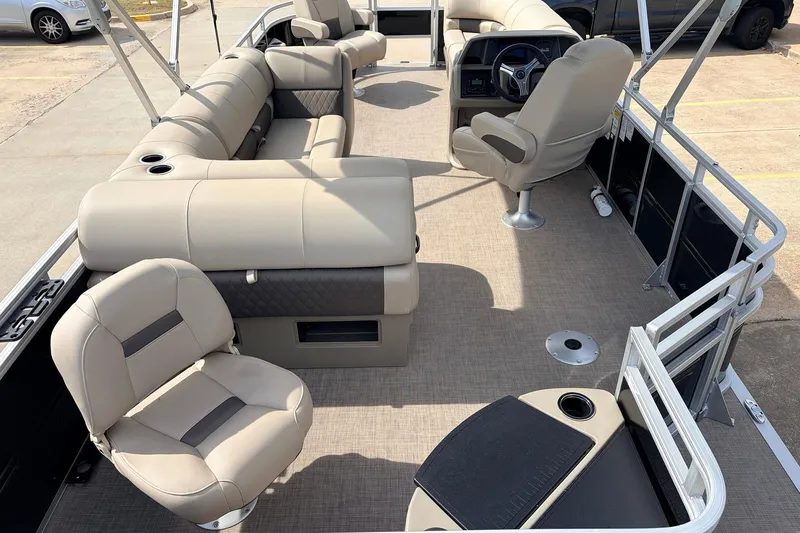 Slide: The Image of 2025 Sun Tracker SportFish 20 DLX pontoon boat interior with beige seating and steering console. - 11