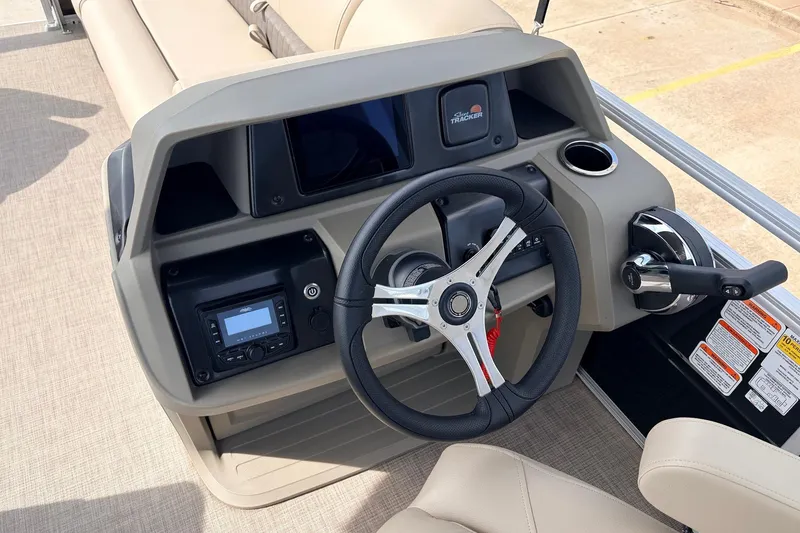 Slide: The Image of 2025 Sun Tracker SportFish 20 DLX boat console with steering wheel and controls. - 30