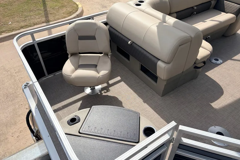 Slide: The Image of 2025 Sun Tracker SportFish 20 DLX pontoon boat interior with beige seating and fishing station. - 35