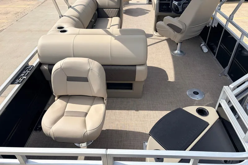 Slide: The Image of 2025 Sun Tracker SportFish 20 DLX pontoon boat interior with beige seating and helm. - 36