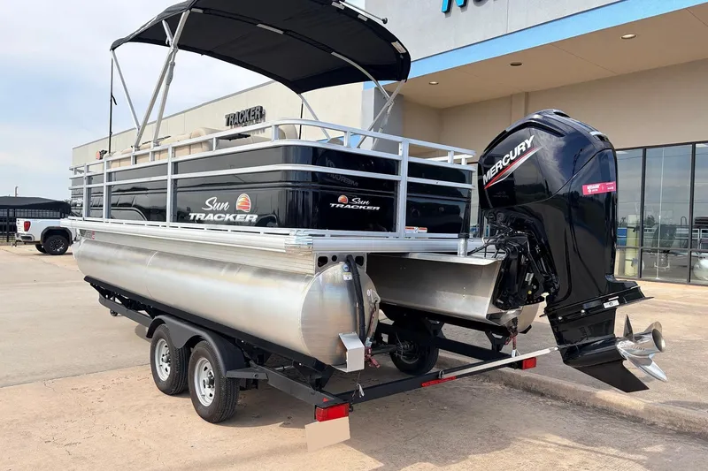 Slide: The Image of 2025 Sun Tracker SportFish 20 DLX pontoon boat with Mercury outboard motor on trailer. - 9