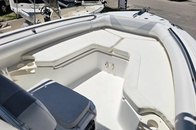 Slide: The Image of 2012 Boston Whaler 220 Outrage boat interior with white cushioned seating. - 11