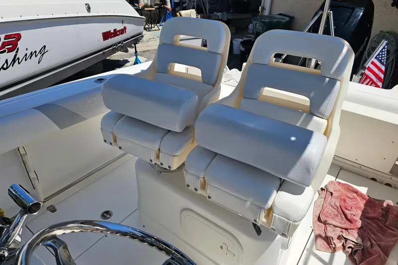 Slide: The Image of Boston Whaler 220 Outrage 2012 boat seats with white upholstery and American flag in background. - 15