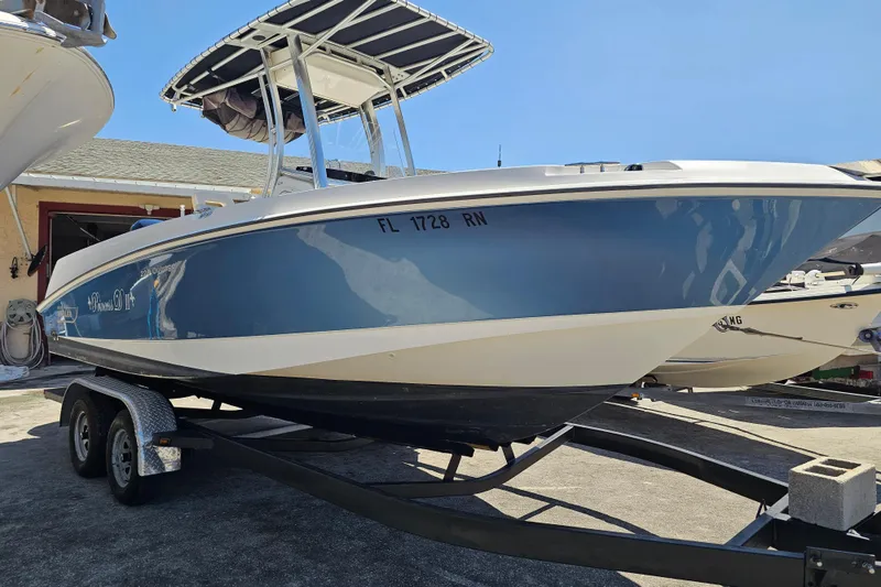 Slide: The Image of 2012 Boston Whaler 220 Outrage boat on trailer, blue hull, sunny day. - 5