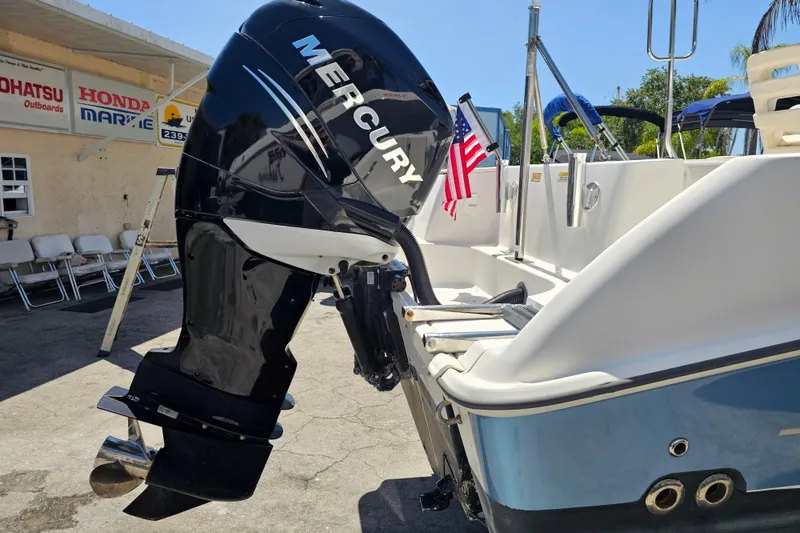 Slide: The Image of 2012 Boston Whaler 220 Outrage with Mercury outboard motor, docked near marine shop. - 6