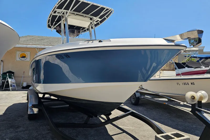 Slide: The Image of 2012 Boston Whaler 220 Outrage boat with Mercury engine on trailer, parked outdoors. - 9