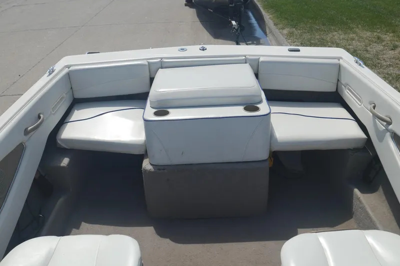 Slide: The Image of 2003 Bayliner 194 boat interior with white seating and cup holders. - 15