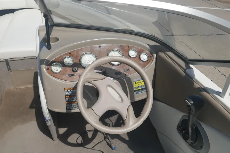 Slide: The Image of 2003 Bayliner 194 boat dashboard with steering wheel and instrument panel. - 16