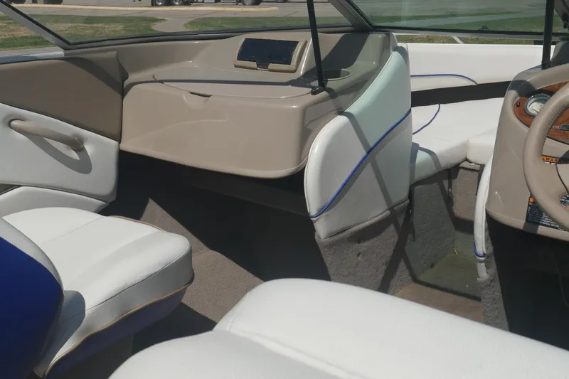 Slide: The Image of 2003 Bayliner 194 boat interior with white seating and beige dashboard. - 19