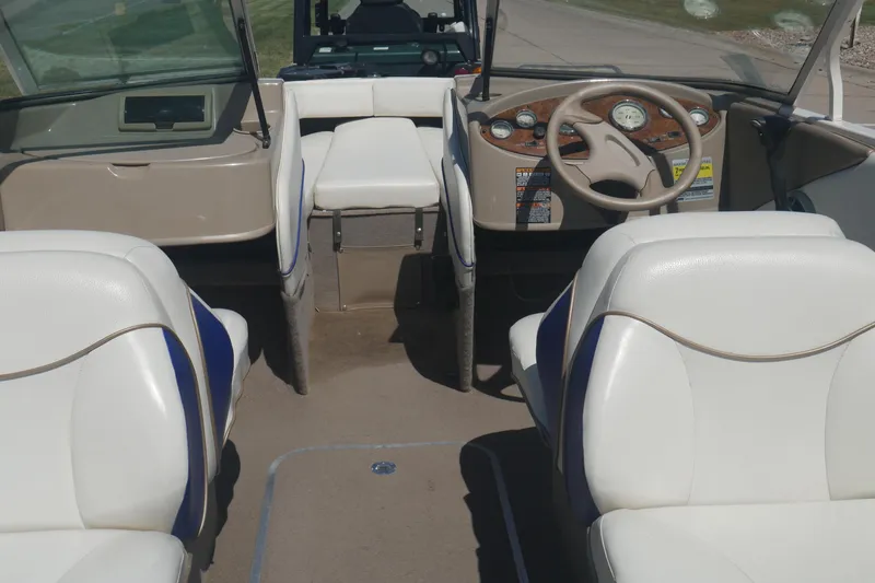 Slide: The Image of Interior of a 2003 Bayliner 194 boat with white seating and dashboard. - 20