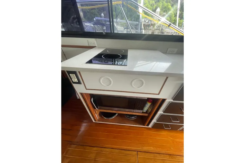 Slide: The Image of 1986 Hi-Star 40 Flybridge yacht kitchen with modern stovetop and wooden flooring. - 11