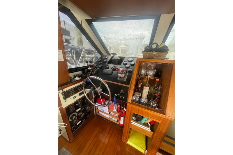 Slide: The Image of 1986 Hi-Star 40 Flybridge helm with steering wheel, controls, and wooden cabinetry. - 18