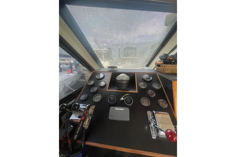 Slide: The Image of 1986 Hi-Star 40 Flybridge helm with gauges and controls, featuring Raymarine equipment. - 19