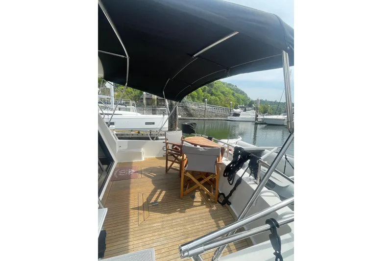 Slide: The Image of 1986 Hi-Star 40 Flybridge yacht with shaded deck, docked in a serene marina setting. - 2