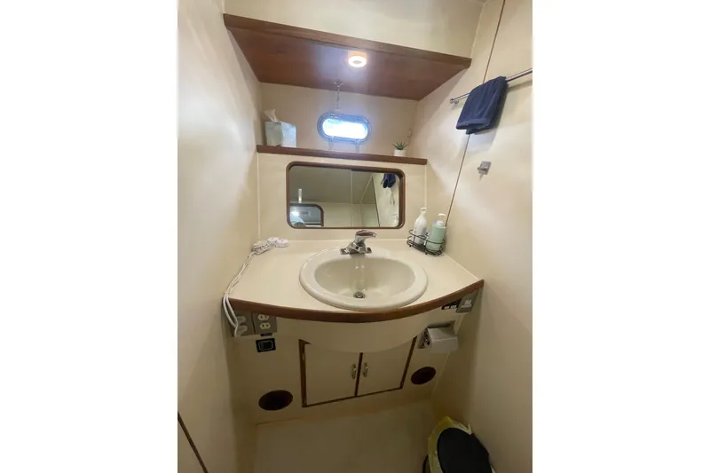 Slide: The Image of Compact bathroom on 1986 Hi-Star 40 Flybridge yacht with sink, mirror, and storage. - 27