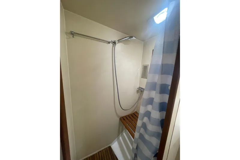 Slide: The Image of Shower area in 1986 Hi-Star 40 Flybridge yacht with striped curtain and wooden floor. - 28