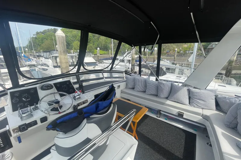 Slide: The Image of 1986 Hi-Star 40 Flybridge yacht interior with helm, seating, and marina view. - 33