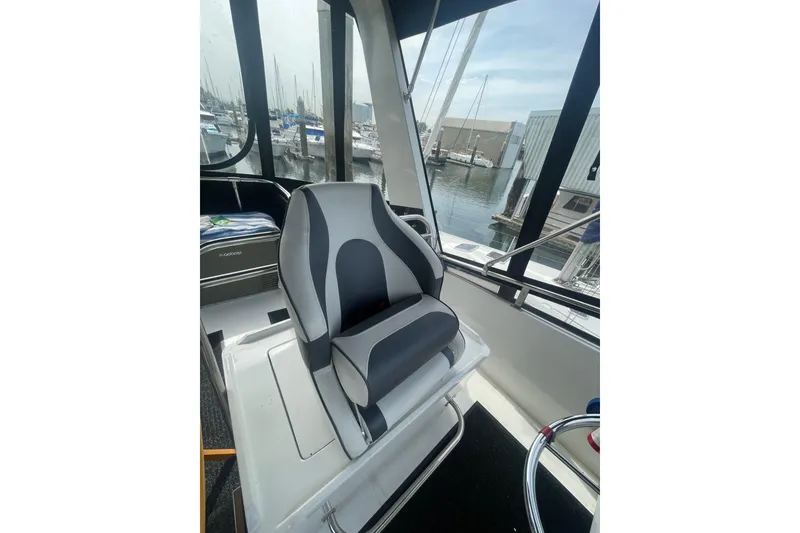 Slide: The Image of Captain's chair on 1986 Hi-Star 40 Flybridge, overlooking marina through large windows. - 35