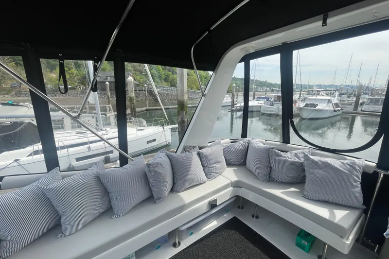 Slide: The Image of Interior view of 1986 Hi-Star 40 Flybridge yacht with cushioned seating and marina backdrop. - 36