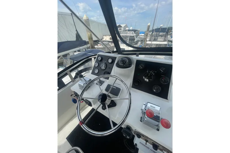 Slide: The Image of 1986 Hi-Star 40 Flybridge helm with steering wheel and control panel, docked at marina. - 38