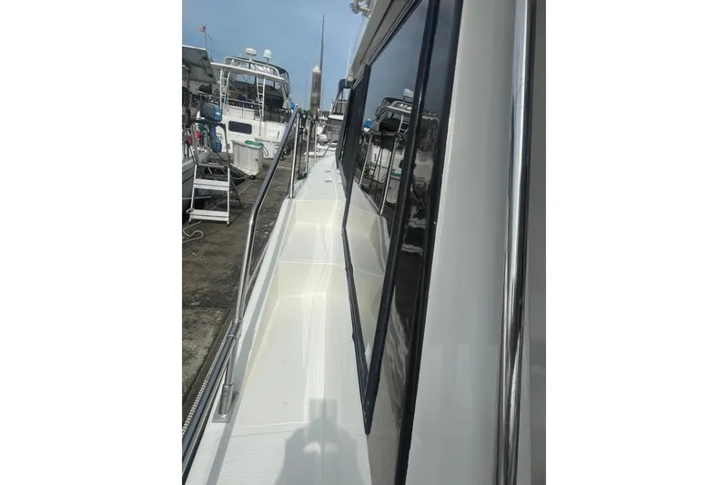 Slide: The Image of 1986 Hi-Star 40 Flybridge yacht side view with railing and docked boats. - 4