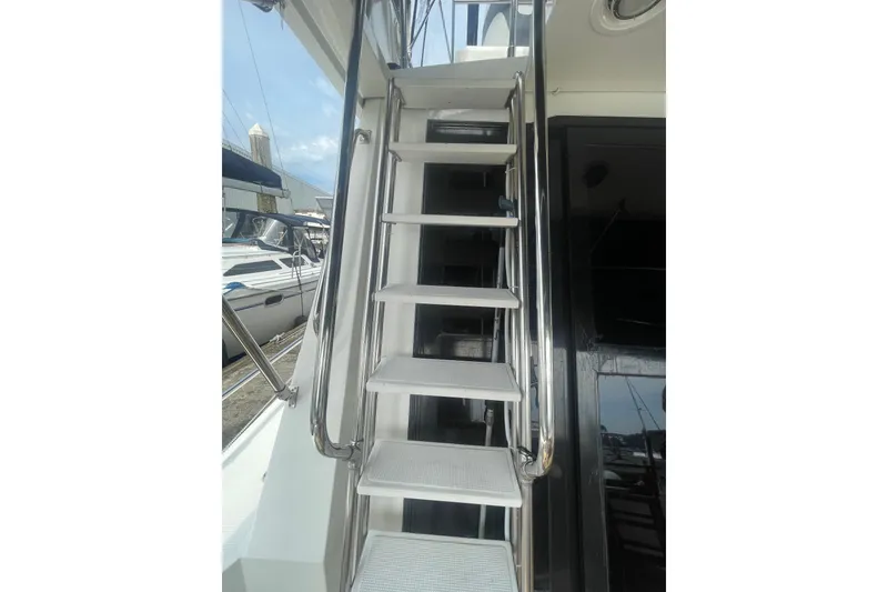 Slide: The Image of Staircase on 1986 Hi-Star 40 Flybridge yacht, featuring sleek metal railings. - 6