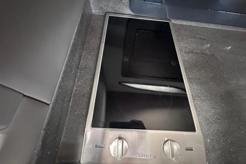 Slide: The Image of Sleek black cooktop with stainless steel knobs on a custom express cruiser crossover, 2017 model. - 17