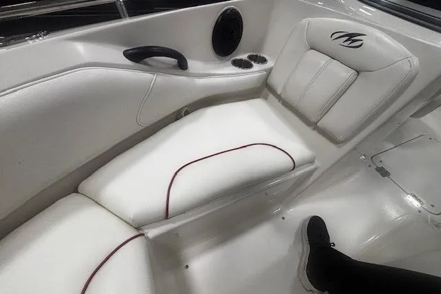 Slide: The Image of Interior seating of a 2008 Monterey 194FS boat, featuring white upholstery and cup holders. - 29