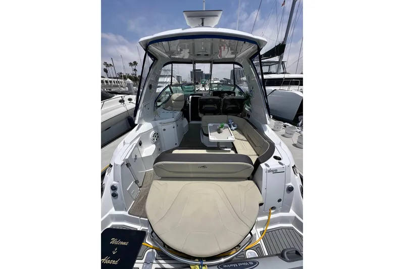 Slide: The Image of 2020 Monterey 355 Sport Yacht interior with seating and table, docked at marina. - 16
