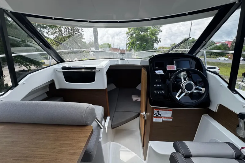Slide: The Image of Interior view of 2019 Jeanneau NC 795 boat cockpit with steering wheel and seating. - 12