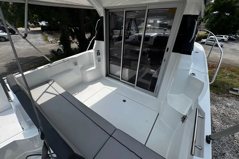 Slide: The Image of 2019 Jeanneau NC 795 boat deck with seating and sliding glass doors. - 2