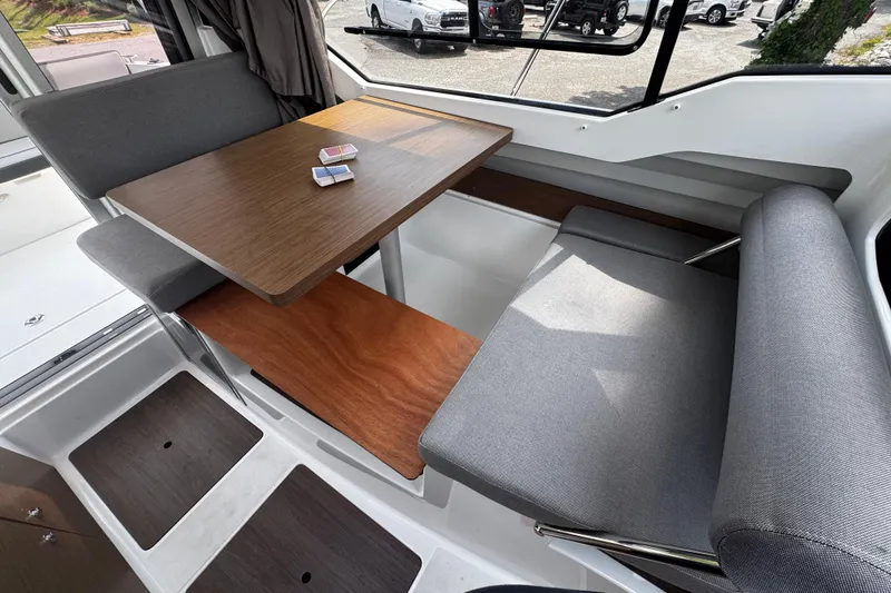 Slide: The Image of Interior of 2019 Jeanneau NC 795 boat with dining area and card deck on table. - 4