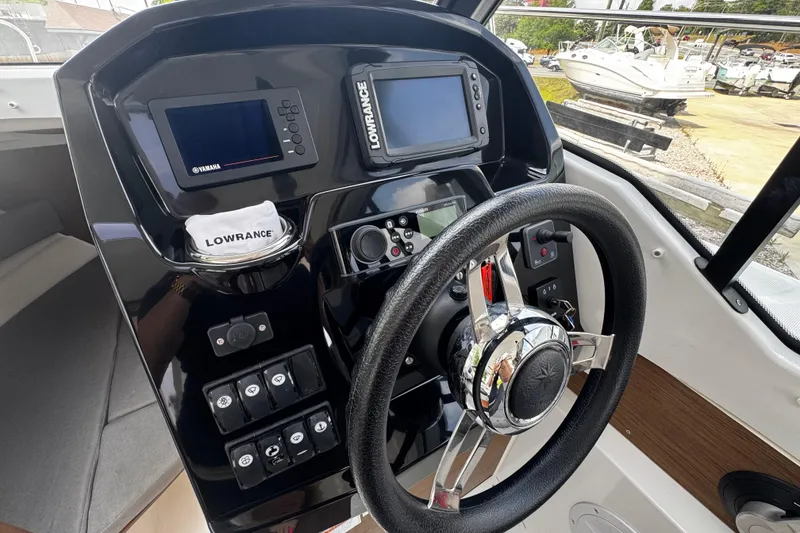 Slide: The Image of 2019 Jeanneau NC 795 helm with Lowrance and Yamaha displays, steering wheel, and control panel. - 6