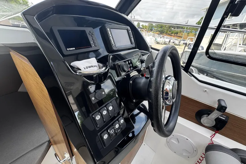 Slide: The Image of Cockpit of 2019 Jeanneau NC 795 boat with steering wheel and navigation controls. - 7