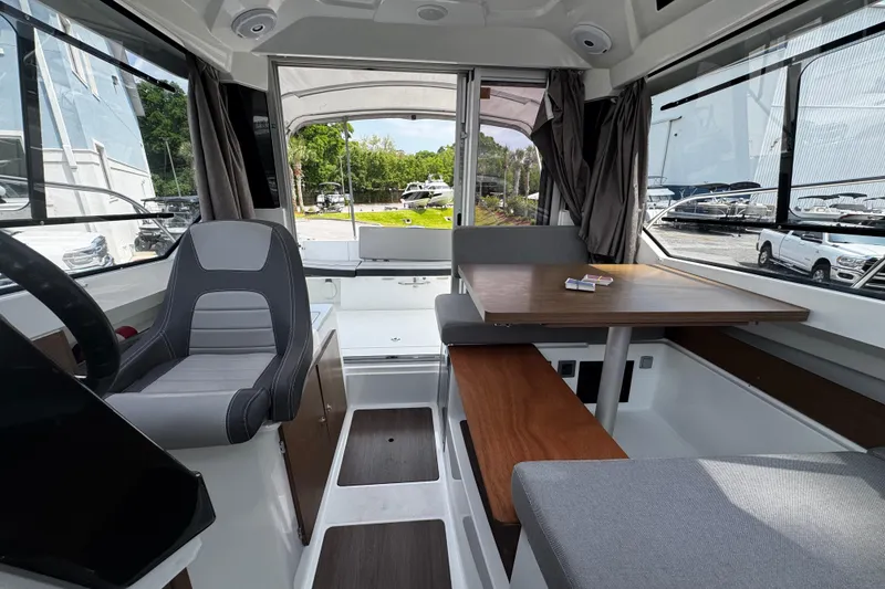 Slide: The Image of Interior of 2019 Jeanneau NC 795 boat with seating and table, docked outdoors. - 8