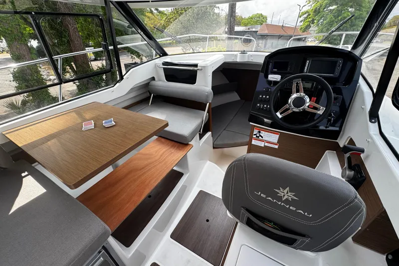 Slide: The Image of Interior of 2019 Jeanneau NC 795 boat, featuring helm, seating, and table. - 9