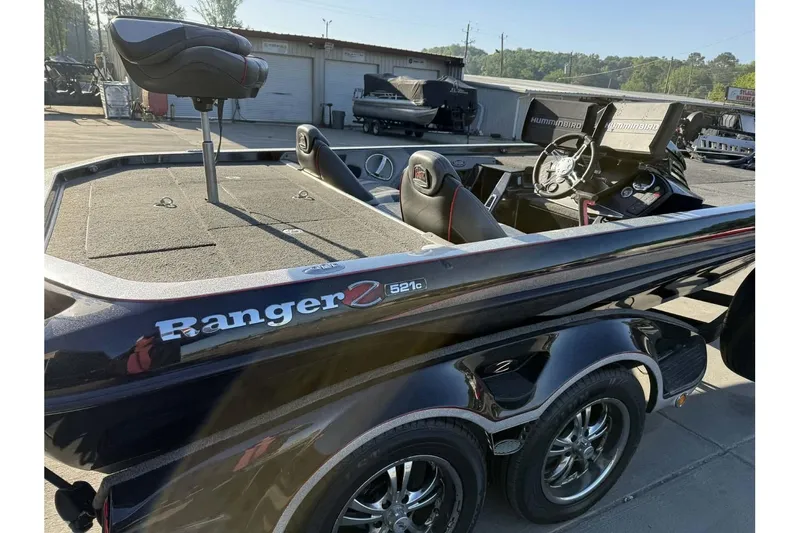 Slide: The Image of 2016 Ranger Z521 Comanche boat with dual consoles and fishing seat, parked outdoors. - 22