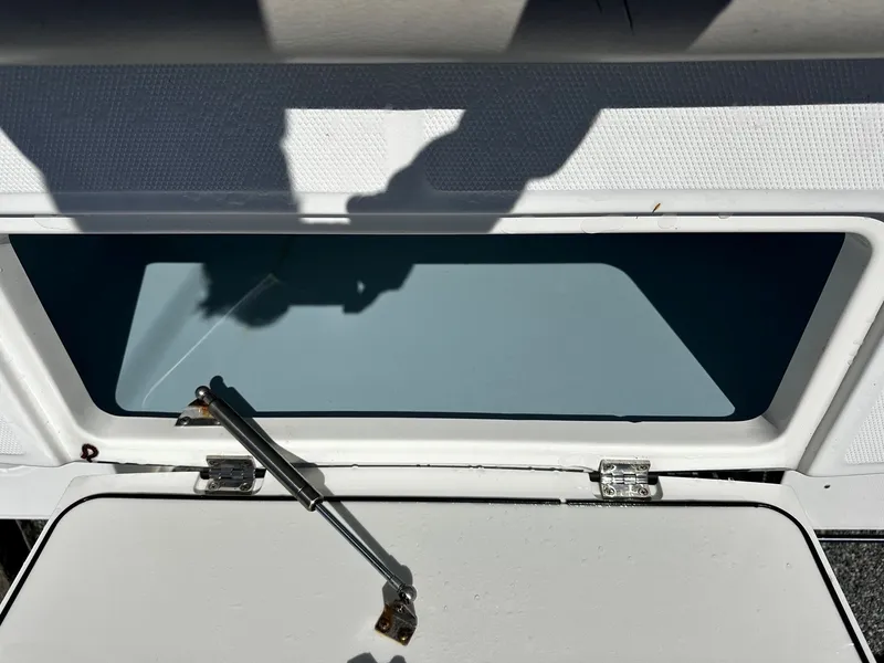 Slide: The Image of Boston Whaler 330 Outrage 2019 storage compartment with open lid. - 13