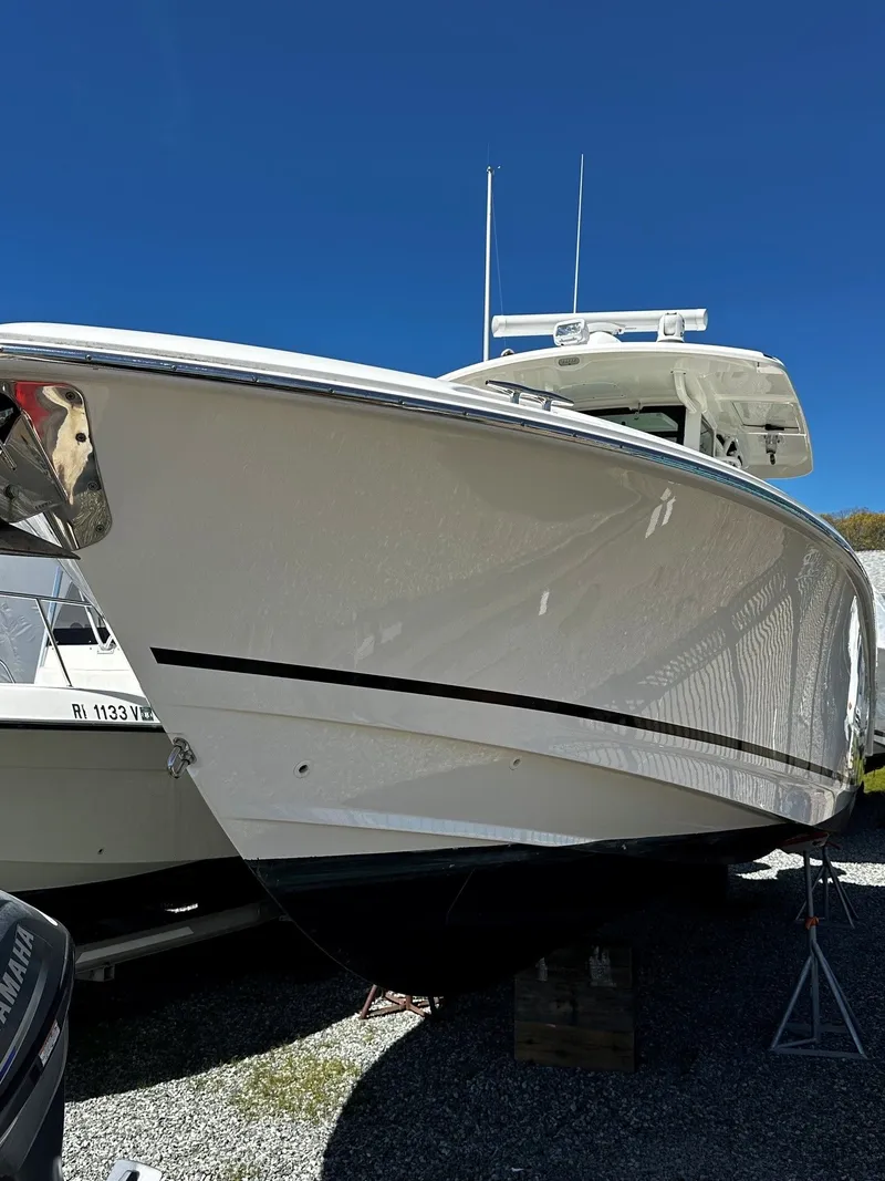 Slide: The Image of 2019 Boston Whaler 330 Outrage boat on gravel lot. - 2