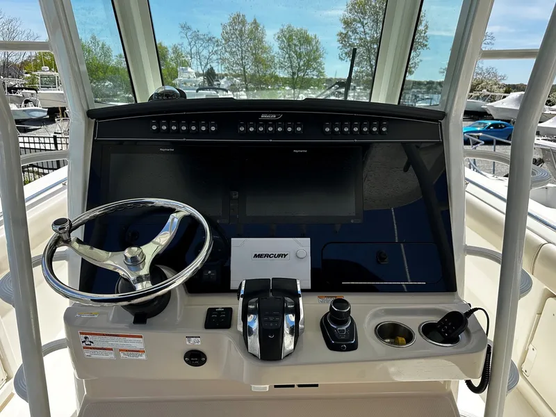 Slide: The Image of 2019 Boston Whaler 330 Outrage helm with steering wheel and controls. - 20