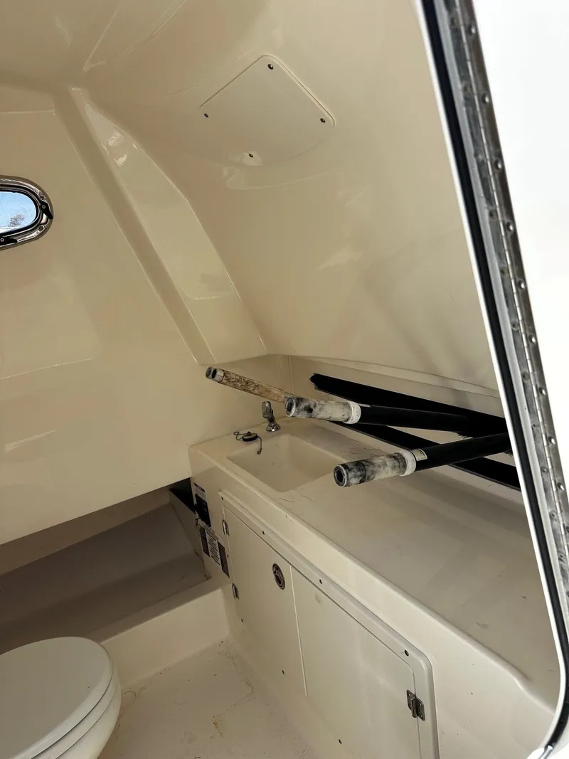Slide: The Image of Interior of 2019 Boston Whaler 330 Outrage with sink and fishing rods. - 28