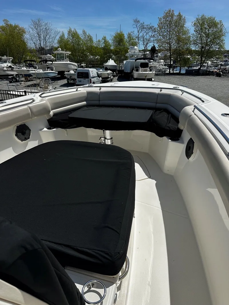 Slide: The Image of 2019 Boston Whaler 330 Outrage boat with cushioned seating at the harbor. - 30