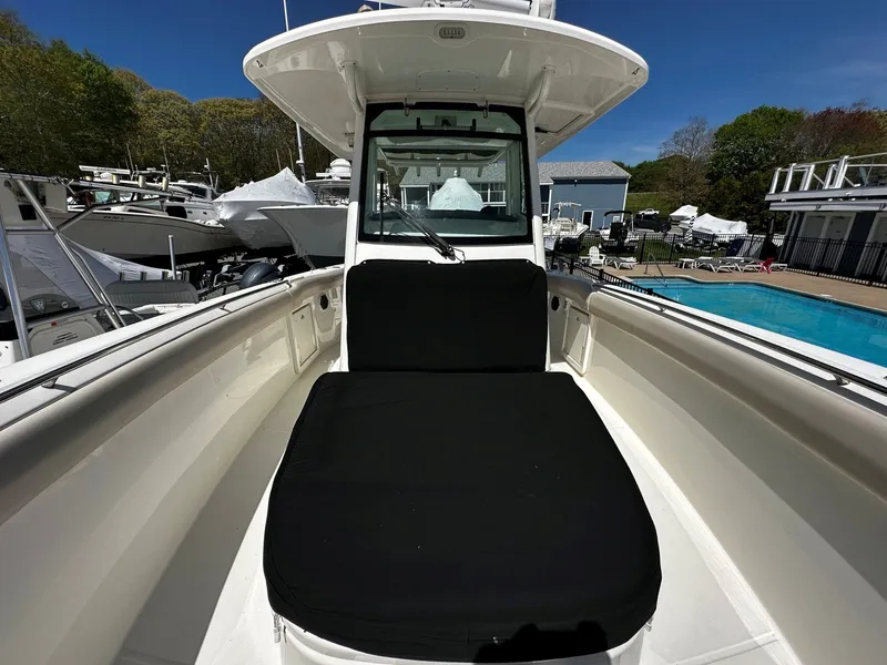 Slide: The Image of 2019 Boston Whaler 330 Outrage with black seat cushion, parked outdoors. - 32