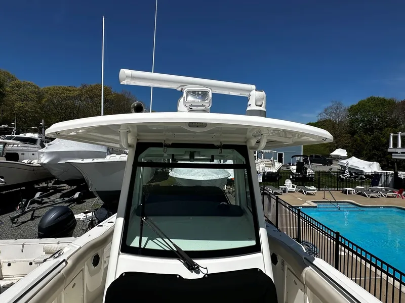 Slide: The Image of 2019 Boston Whaler 330 Outrage boat by the pool, sunny day. - 33