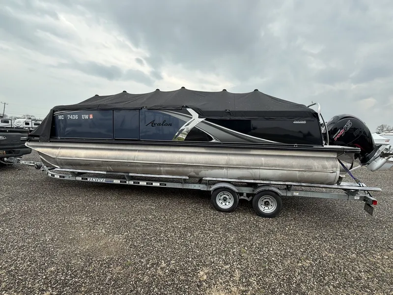 The Image of 2023 Avalon 2385 LSZ pontoon boat on trailer, cloudy sky. - 0