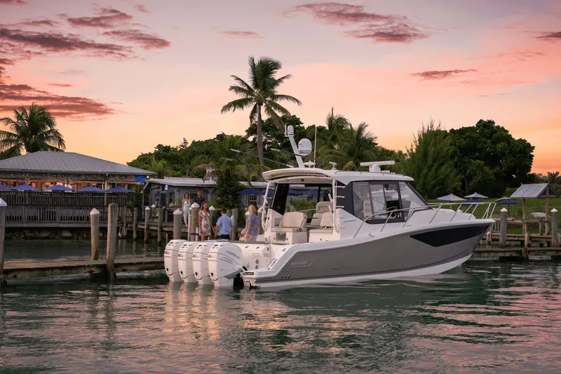 Slide: The Image of A Boston Whaler 405 Conquest docked at sunset, surrounded by palm trees. - 38