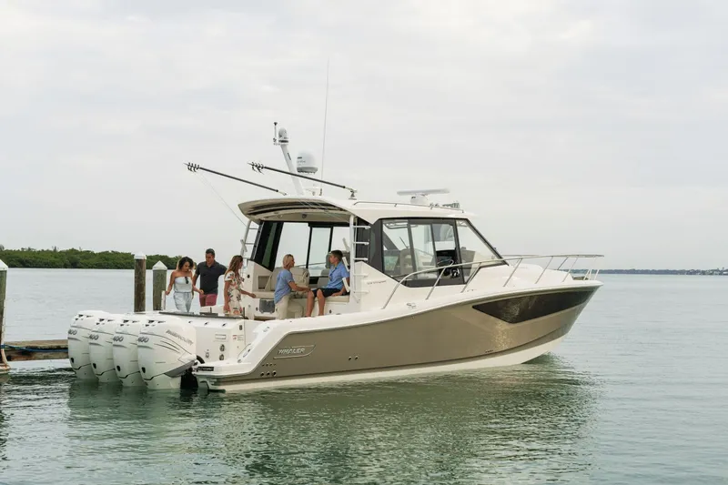 Slide: The Image of A 2026 Boston Whaler 405 Conquest is docked. Several people are standing on board. - 4
