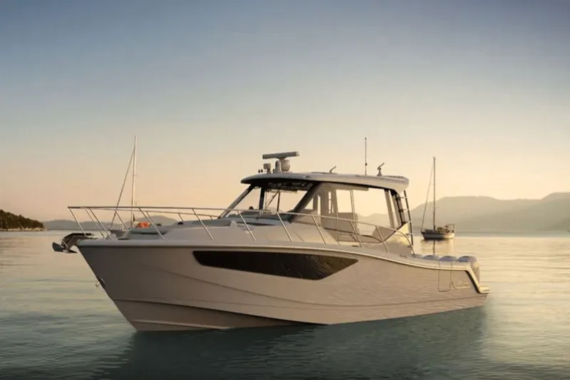 Slide: The Image of A sleek motorboat, the Boston Whaler 405 Conquest, rests calmly on the water at sunset. - 6