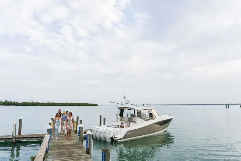 Slide: The Image of A group of people walks on a dock towards a Boston Whaler 405 Conquest boat. - 8