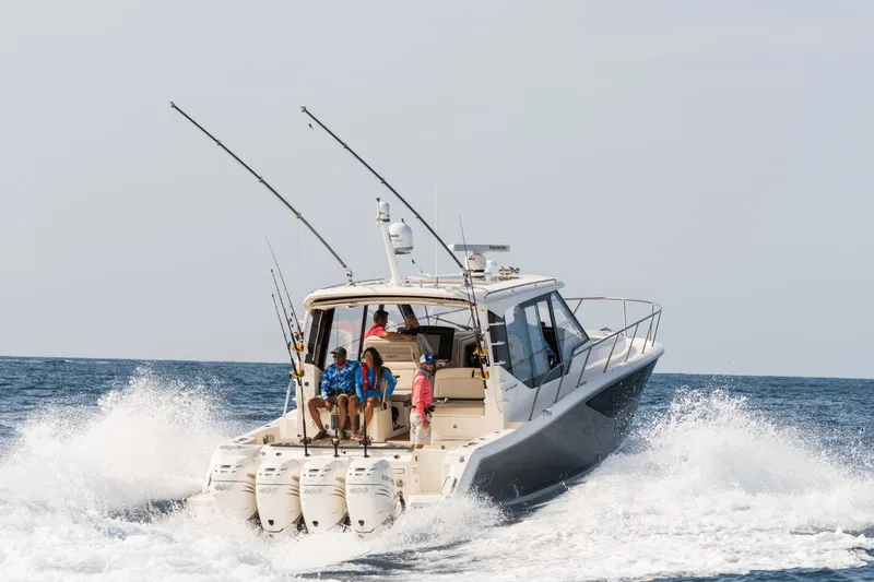 Slide: The Image of Boston Whaler 405 Conquest 2026 on the water with fishing rods and four outboard engines. - 25
